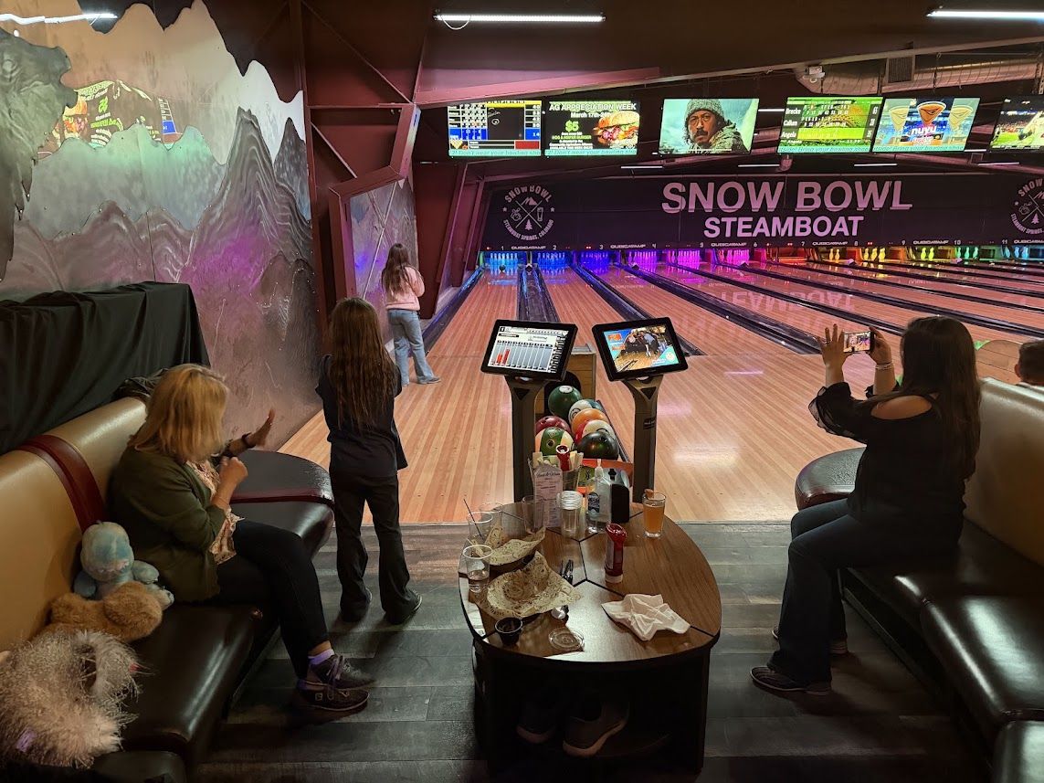 Snow Bowl Steamboat bowling alley — lanes, scoring monitors, and mountain mural
