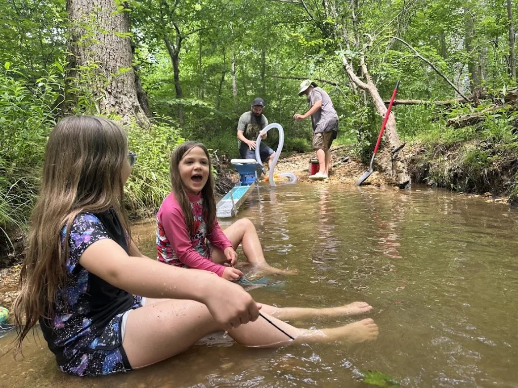 Dave Horsley gold prospecting in a woodland stream with family and a sluice box
